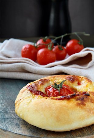 Italian Focaccia bread with tomato and cheese on the board Stock Photo - Budget Royalty-Free & Subscription, Code: 400-04300448