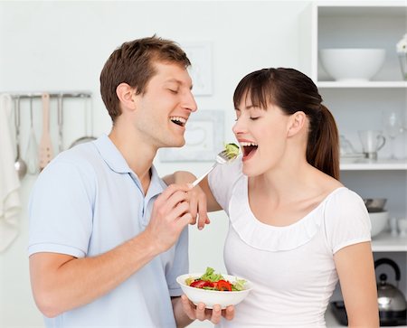 simsearch:400-04853599,k - Happy couple eating together in the kitchen Foto de stock - Royalty-Free Super Valor e Assinatura, Número: 400-04300878