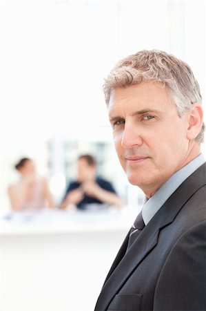 simsearch:400-04113098,k - Businessman looking at the camera while his team is working in the background Stock Photo - Budget Royalty-Free & Subscription, Code: 400-04301926