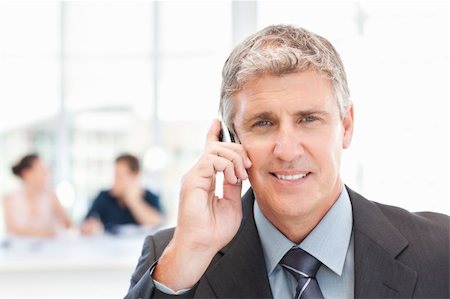 simsearch:400-04113098,k - Businessman phoning  while his team is working in the background Stock Photo - Budget Royalty-Free & Subscription, Code: 400-04301923