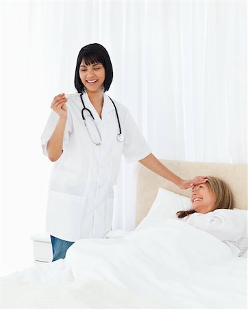 simsearch:400-04809124,k - Nurse taking the temperature of  her patient Stockbilder - Microstock & Abonnement, Bildnummer: 400-04302035