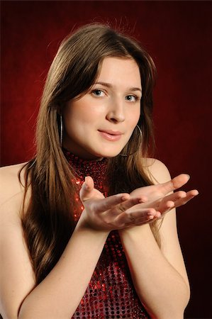 side lips view pictures - Young woman holding hand presenting a product.On a red background Stock Photo - Budget Royalty-Free & Subscription, Code: 400-04302128