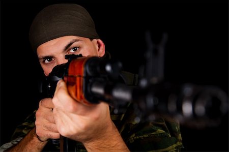 simsearch:841-06341908,k - Soldier in uniform with rifle, selective focus on face Stockbilder - Microstock & Abonnement, Bildnummer: 400-04302177