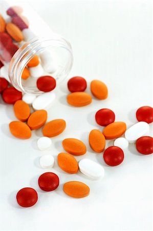 simsearch:400-08862116,k - Health concept: high key picture of colorful pills with open plastic bottle barely visible on stark white sterile background with slight shadows. Stock Photo - Budget Royalty-Free & Subscription, Code: 400-04302810