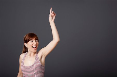 Happy young woman dancing and singing while listen music Stock Photo - Budget Royalty-Free & Subscription, Code: 400-04303331