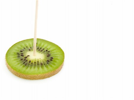 One slice of a kiwi is penetrated by a toothpick made of a tree Stockbilder - Microstock & Abonnement, Bildnummer: 400-04303528