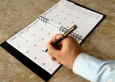 Man filling out  monthly planner on the table Photographie de stock - Aubaine LD & Abonnement, Code: 400-04314989