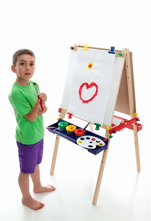school boy in shorts - A young boy child stands by an easel with a beginning of a picture painted.  White background. Stock Photo - Budget Royalty-Free & Subscription, Code: 400-04315332