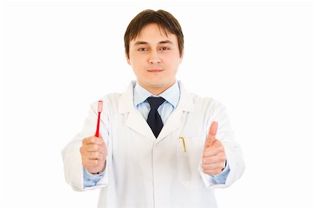 simsearch:400-04351236,k - Smiling dentist holding toothbrush and showing  thumbs up gesture  isolated on white Photographie de stock - Aubaine LD & Abonnement, Code: 400-04315990