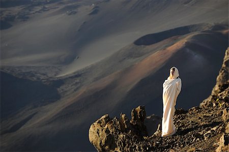 simsearch:841-03067371,k - The girl at craters of Haleakala. Early morning, a smoke, wrapped up in white the girl in rising sun beams costs at edge of breakage against craters. Stock Photo - Budget Royalty-Free & Subscription, Code: 400-04316428