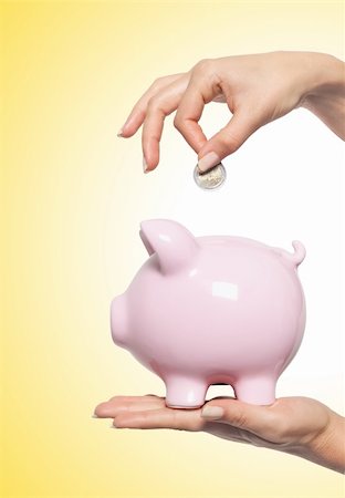 simsearch:400-04995456,k - Hand putting money into the piggy bank over yellow background Stockbilder - Microstock & Abonnement, Bildnummer: 400-04317193