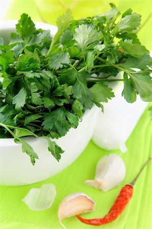 sprigs of oregano - green parsley in a mortar with garlic and pepper on a green napkin Stock Photo - Budget Royalty-Free & Subscription, Code: 400-04317855