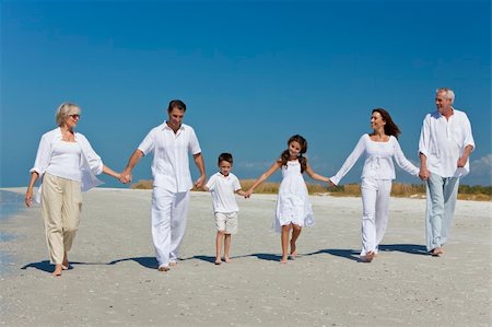 A happy family of grandparents, mother, father, two children, son and daughter, walking holding hands and having fun on a sunny beach Stock Photo - Budget Royalty-Free & Subscription, Code: 400-04318046