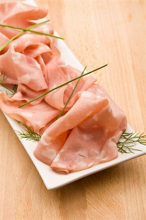 photo of thin slices of italian mortadella called also bologna on small rectangular plate served as appetizer Photographie de stock - Aubaine LD & Abonnement, Code: 400-04318448