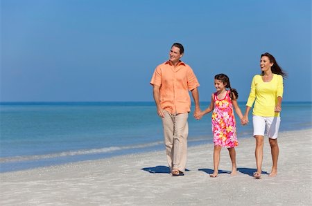 simsearch:400-04235471,k - A happy family of mother, father and daughter, holding hands and walking in the sand of a sunny beach Stock Photo - Budget Royalty-Free & Subscription, Code: 400-04318777