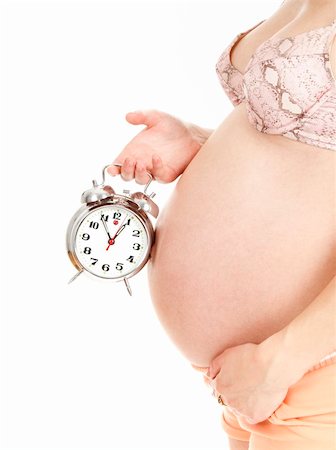 simsearch:400-06849973,k - Portrait of young pregnant woman hoding an alarm clock on her belly, isolated on white background. Stock Photo - Budget Royalty-Free & Subscription, Code: 400-04310094