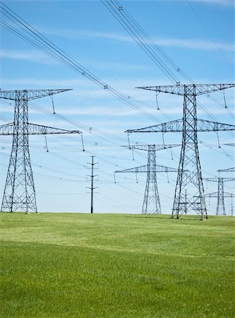 simsearch:400-04838002,k - Power lines and pylons running across a green field with blue sky in the background. Foto de stock - Royalty-Free Super Valor e Assinatura, Número: 400-04310133