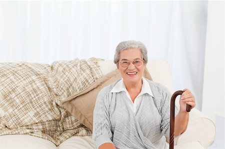 Mature woman sitting on the sofa with her walking stick at home Stock Photo - Budget Royalty-Free & Subscription, Code: 400-04311138