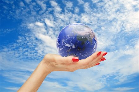hand and earth (globe) over blue sky Stock Photo - Budget Royalty-Free & Subscription, Code: 400-04311311