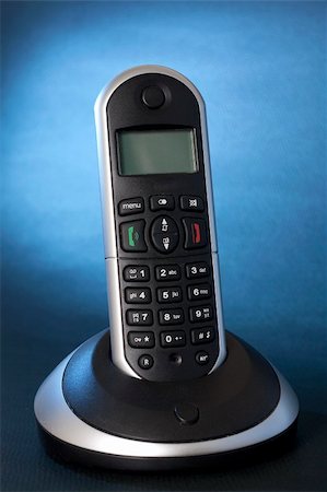A black wireless telephone on a cradle, background focus with  blue gel Stock Photo - Budget Royalty-Free & Subscription, Code: 400-04311665
