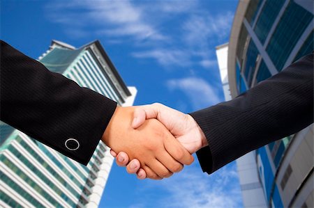 simsearch:400-06742694,k - Business people shaking hands against blue sky and modern building Foto de stock - Super Valor sin royalties y Suscripción, Código: 400-04312110