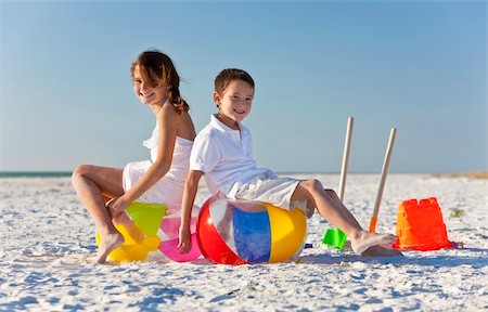 Young children, boy and girl, brother and sister, having fun, playing on a beach with beach balls, buckets and spades Stock Photo - Budget Royalty-Free & Subscription, Code: 400-04312280