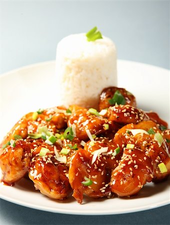 A close-up of a portion of sesame chicken with rice served on a white plate Stock Photo - Budget Royalty-Free & Subscription, Code: 400-04312695