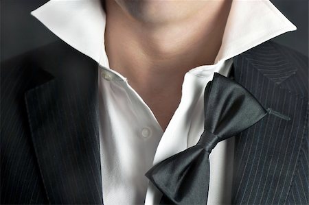 revers - A close-up shot of a man in a tux with his bowtie hanging and his collar undone. Stockbilder - Microstock & Abonnement, Bildnummer: 400-04313348