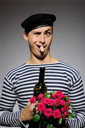 simsearch:400-04655736,k - Funny romantic sailor man opening bottle and holding rose flowers prepared for a date Stockbilder - Microstock & Abonnement, Bildnummer: 400-04313886