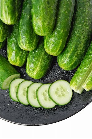 simsearch:400-05705062,k - Cucumbers and a cucumber slices, washed and arranged in a black ceramic plate close-up  isolated on white background Photographie de stock - Aubaine LD & Abonnement, Code: 400-04324555