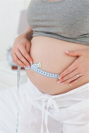 simsearch:400-04266844,k - Close up of a woman measuring her belly at home Stock Photo - Budget Royalty-Free & Subscription, Code: 400-04324776