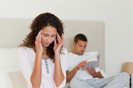 simsearch:649-03487806,k - Woman having a headache while her husband is reading Stock Photo - Budget Royalty-Free & Subscription, Code: 400-04324836