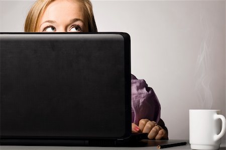 programmer (female) - young curious woman is looking out of laptop at office Stock Photo - Budget Royalty-Free & Subscription, Code: 400-04325523