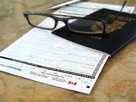 Canada passport on declaration card with glasses and pen Fotografie stock - Microstock e Abbonamento, Codice: 400-04325672