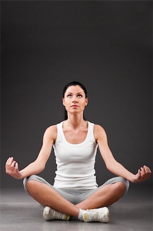 simsearch:400-04361224,k - sporty woman is relaxing in lotus pose on grey background Stock Photo - Budget Royalty-Free & Subscription, Code: 400-04325990
