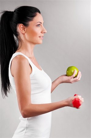 simsearch:400-04361224,k - sporty woman is holding red barbell and green apple on grey background Stock Photo - Budget Royalty-Free & Subscription, Code: 400-04325993