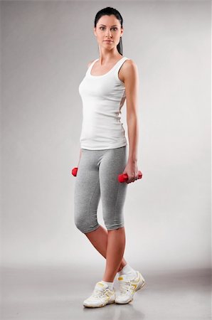 simsearch:400-04361224,k - sporty woman is standing with barbells on grey background Stock Photo - Budget Royalty-Free & Subscription, Code: 400-04326004