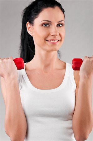 simsearch:400-04361224,k - sporty woman is holding barbells on grey background Stock Photo - Budget Royalty-Free & Subscription, Code: 400-04326003