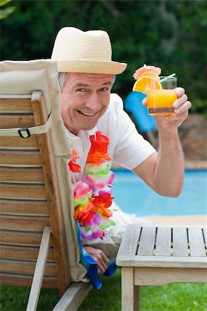 Mature man drinking a cocktail beside the swimming poo Stock Photo - Budget Royalty-Free & Subscription, Code: 400-04326544