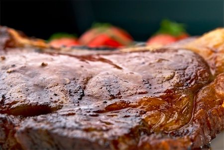 Club Steak. Veal on the bone. Macro of grilled meat ribs on white plate with cherry tomatoes and dark hot sauce Fotografie stock - Microstock e Abbonamento, Codice: 400-04326881