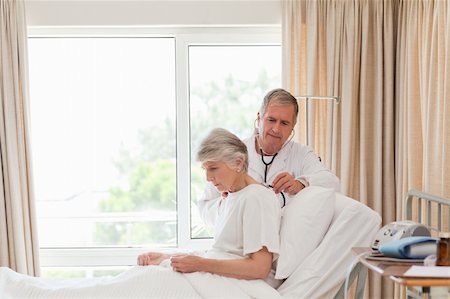 family visiting patient hospital bed - Senior doctor taking the heartbeat of his patient Stock Photo - Budget Royalty-Free & Subscription, Code: 400-04327144