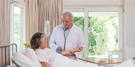 Senior doctor taking the blood pressure of his patient Stock Photo - Budget Royalty-Free & Subscription, Code: 400-04327320