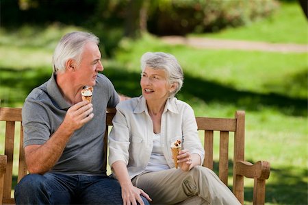 Senior couple eating an ice cream on a bench Stock Photo - Budget Royalty-Free & Subscription, Code: 400-04327692