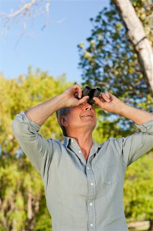 side portrait view older people - Senior man looking at the sky with his binoculars Stock Photo - Budget Royalty-Free & Subscription, Code: 400-04327759