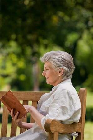 relaxed older lady reading book - Reired woman reading a book on the  bench Foto de stock - Super Valor sin royalties y Suscripción, Código: 400-04327792