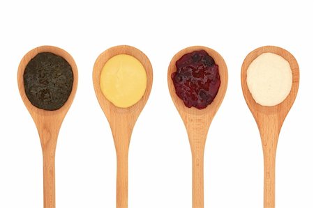 dijon - Mint sauce, mustard, cranberry jelly and horseradish  in four wooden spoons isolated over white background. Foto de stock - Royalty-Free Super Valor e Assinatura, Número: 400-04327824