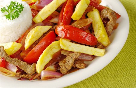 simsearch:400-04855321,k - A typical Peruvian dish called "lomo saltado" which is made of beef, onions, tomatoes and is accompanied by fried potatoes and rice (Selective Focus, Focus on the front of the dish) Stock Photo - Budget Royalty-Free & Subscription, Code: 400-04327978