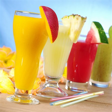 Mango, pineapple, watermelon and kiwi smoothie with drinking straws on wood (Selective Focus, Focus on the mango smoothie in the front) Stock Photo - Budget Royalty-Free & Subscription, Code: 400-04327986