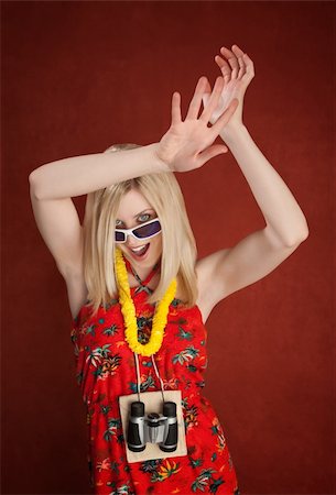 Tourist wearing binoculars and garland around neck dances with hands above her head Stock Photo - Budget Royalty-Free & Subscription, Code: 400-04328069