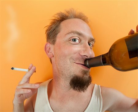 drinking problem - Happy Caucasian man holding a bottle and a cigarette Stock Photo - Budget Royalty-Free & Subscription, Code: 400-04328147